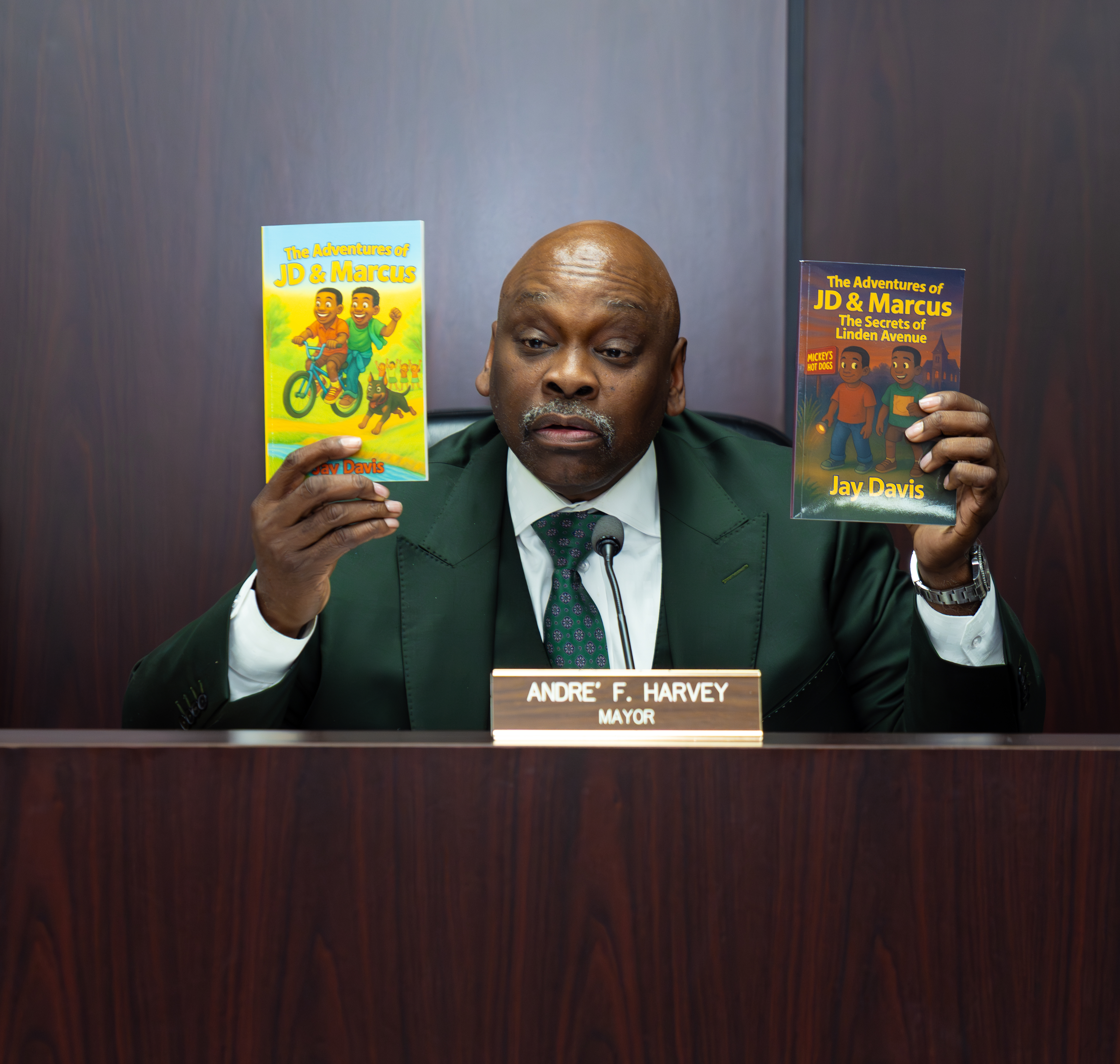 Mayor Andre F. Harvey holds JD & Marcus books